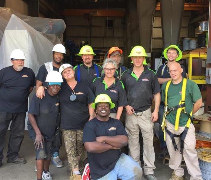 A group of employees in hardhats posing for a picture. 
