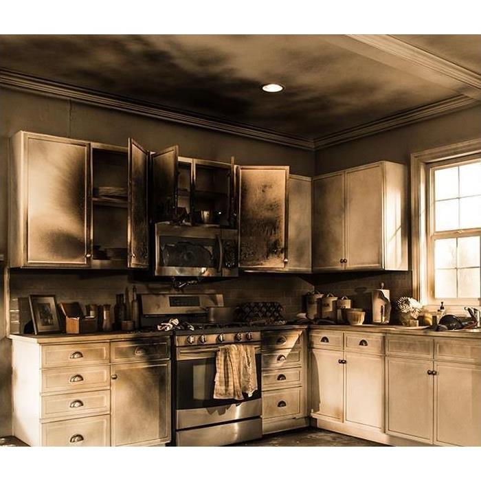 A kitchen with burnt and smoke-stained cabinets and ceiling